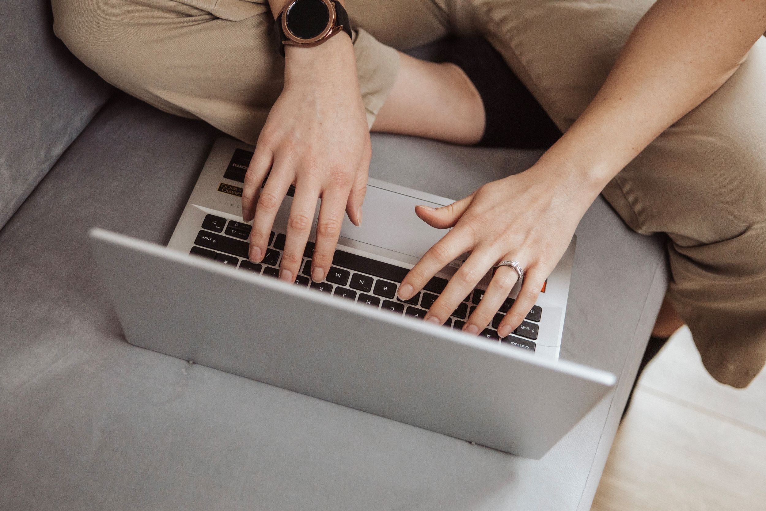 Rowena Blanchard-Heal typing one laptop whilst sitting on sofa